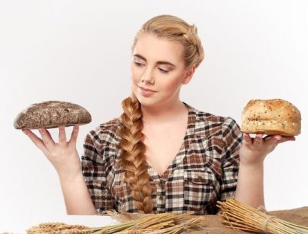 woman choosing between rye and wheat bread